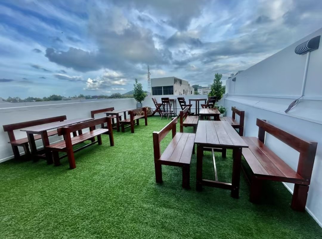 Rooftop garden with wooden benches on green turf